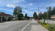 Rautalammin keskuskatu. Kadun molemmin puolin muutama rakennus, yksi auto ajaa tietä pitkin.