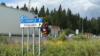 Tienviitta, jossa lukee "Jyväskylä" ja "Pitkäjärvi", ja taustalla kaksi paloautoa moottoritiellä metsän laidassa.