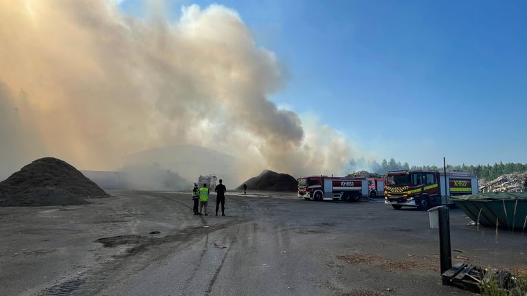 Suuri energiajätekasa palaa. Palosta nousee sankkaa savua. Palavan kansan edessä sammutusautoja ja palomiehiä.