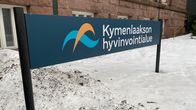 Kymenlaakson hyvinvointialueen kyltti kivisen rakennuksen edessä.