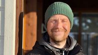 Mies hymyilee kameralle. Aurinko paistaa hieman silmiin. 