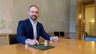 Mies pitää nuijaa ja istuu.