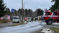 Tie, jonka varrella on useita poliisi- ja paloautoja.