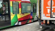 Raitiovaunu ja K-kaupan kuorma-auto pysähtyneinä risteyksessä.
