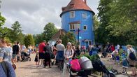 Det blåa muminhuset, runtomkring massa människor, framför allt barn. 