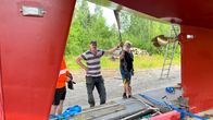 Tapio Tiainen tarkastaa Ari Harjun kanssa kuljetuslavetille nostetun veneen kiinnikkeitä.