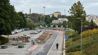 Kuvassa näkyy urbaani puistomainen alue, jossa on jalkakäytäviä ja pyöräteitä. Etualalla on parkkipaikka sekä kävely- ja pyöräilyreitti.