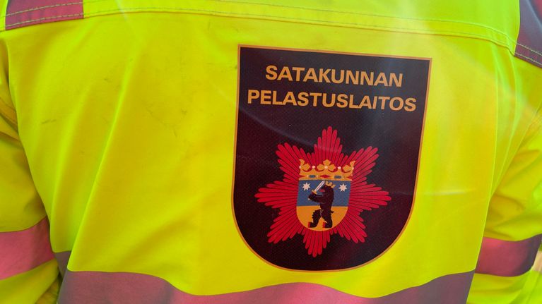 Heijastava työtakki, jonka selässä on logo, jossa lukee Satakunnan pelastuslaitos.