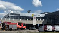 Kuvassa pelastajat sammuttavat vedellä palavan autoliikkeen kattoa.