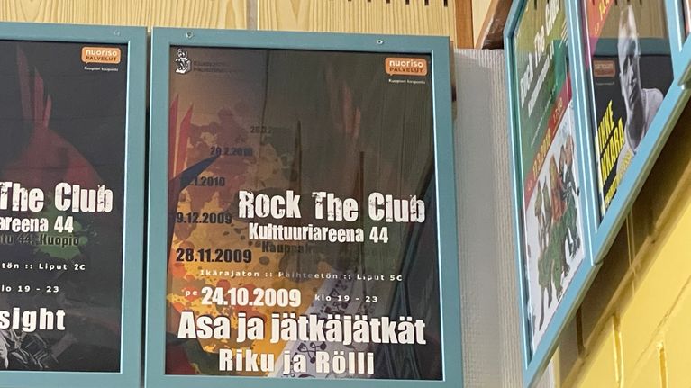Kehystettyjä tapahtumajulisteita seinällä. 
