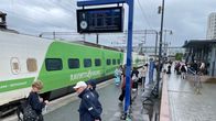 Matkustajia odottamass Mikkelin juna-asemalla korvaavaa kuljetusta myrskypäivänä.