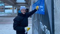 Mies puhdistamassa graffitia Itä-Pasilassa.