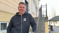 Mies nojaa portaiden kaiteeseen ja katsoo kameraan.