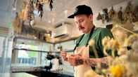 Erik Mansikka asettelee kukkasia jälkiruoka-annokseen.