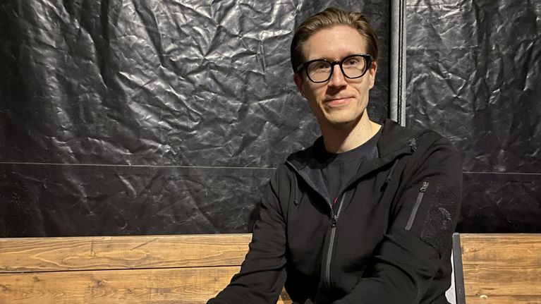 Juho Peltonen istuu sirkusteltan katsomossa ja katsoo kameraan.
