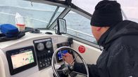 Veneen kuljettaja säätää karttaplotteria.