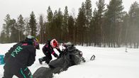 Nainen työntää kelkkaa umpihangessa.