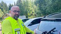 Huomioliiviin pukeutunut mies, pitää kiinni maastopyörän tangosta. 