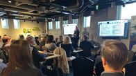 Kuvassa näkyy  hotellin kokoushuoneessa oleva seminaari, jossa yleisö kuuntelee esiintyjää. 