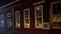 Kortesjärven Ylikylän Nuorisoseuran talo valaistuna sähkökynttilöillä.
