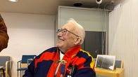 Hans Niittyvuopio istuu Utsjoen kunnantalolla gákti päällä ja hymyilee katsoen yläviistoon sivulle.