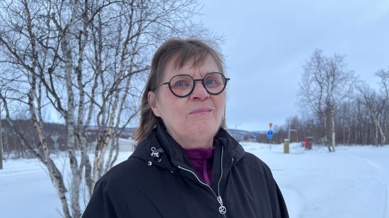 Birit Vuolab seisoo Utsjoella valtatien lähettyvillä lumisessa maisemassa.