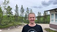 Annika Saarto seisoo hiekkatiellä Kevon tutkimuslaitoksessa rakennuksen edustalla metsäisessä maisemassa.
