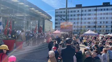 Ihmiset seuraavat torilavalla olevaa ohjelmaa.