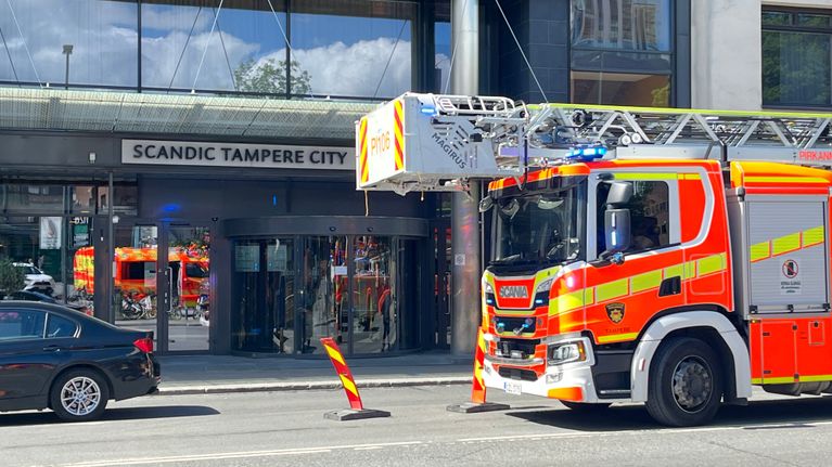 Pelastuslaitoksen paloauto pysäköitynä Scandic Tampere City -hotellin sisäänkäynnin eteen, katu suljettu liikennemerkillä.
