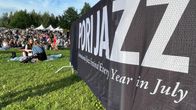 Pori Jazz -kyltti ja ihmisiä nurmikolla.