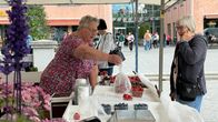 Torikauppias Kaija Ahonen ojentaa mansikkarasian Tuula Suuroselle.