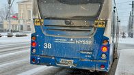 Bussi liikenteessä talvisessa säässä. Kyseessä on Tampereen kaupungin liikenteen Nyssen linja-auto, linjanumero 38. Lumisade näkyy taustalla.