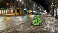 Sähköpotkulautoja rivissä aution kadun varrella illalla.