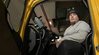 Aura-auton kuljettaja Jarmo Putaansuu istuu aura-auton ratin takana.