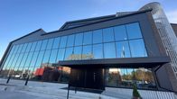En kontorsbyggnad med stora fönster och en huvudingång med namnet "Mirka" ovanför.