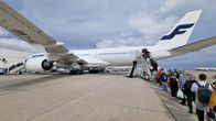 People lining up at the back end of a jet on the tarmac.