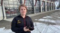 Palomestari Oona Englund seisoo Kokkolan paloaseman edustalla kädessään kännykkä ja virve