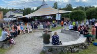 Kaustisen festivaalien yleisöä vuonna 2023 istuskelemassa iltanuotiopaikalla päiväsaikaan.