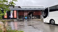 Saamelaismuseo Siidan pihalla linja-auto ja asiakkaat kävelevät sisälle museoon, 16.8.2023 Inarissa.