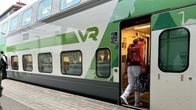Ihminen nousee paikallaan asemalaiturilla olevaan pikajunaan. 
