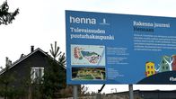 Lähikuvassa on mainoskyltti. Sininen iso mainoskyltti mainostaa uutta kaupunginosaa.