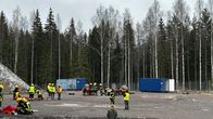 Hiekkakentällä palomiehet auttavat loukkaantuneita suuronnettomuusharjoituksessa.