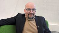Janakkalan kunnanvaltuuston puheenjohtaja Marko Ahtiaine istuu vihreällä sohvalla.
