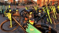Lähikuvassa on keltaisia polkupyöriä pysäköitynä kadulle. 