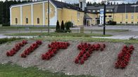 Kukkaistutus jonka takana on keltainen suuri betonirakennus.