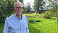 Puutarhassa seisoo mies, jolla on silmälasit ja viikset.