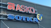 Asko ja Sotka -logot harmaassa ulkoseinässä. Kylteissä ja seinässä ohut pakkashuurre.