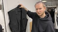 Nuori mies pitää henkaria, jossa on keskeneräinen puvun takki.