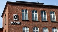 Hämeen ammattikorkeakoulun HAMK logo tiilirakennuksen seinällä. 