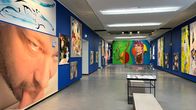 Taidemuseon siniseinäisessä näyttelytilassa esillä värikkäitä teoksia.